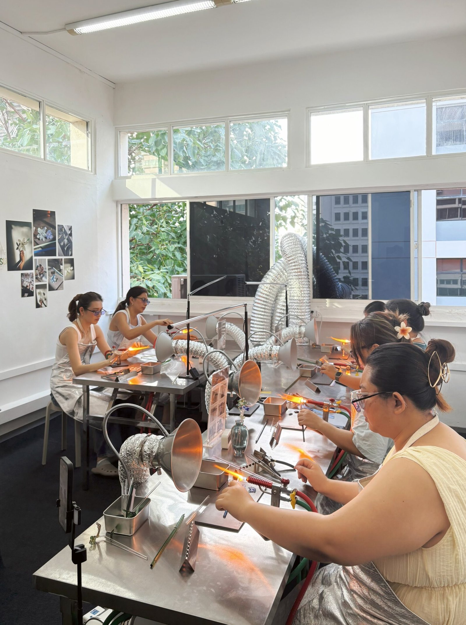 Private Hen's party group of 6 ladies creating unique glass flower art at a lampworking workshop in Singapore.